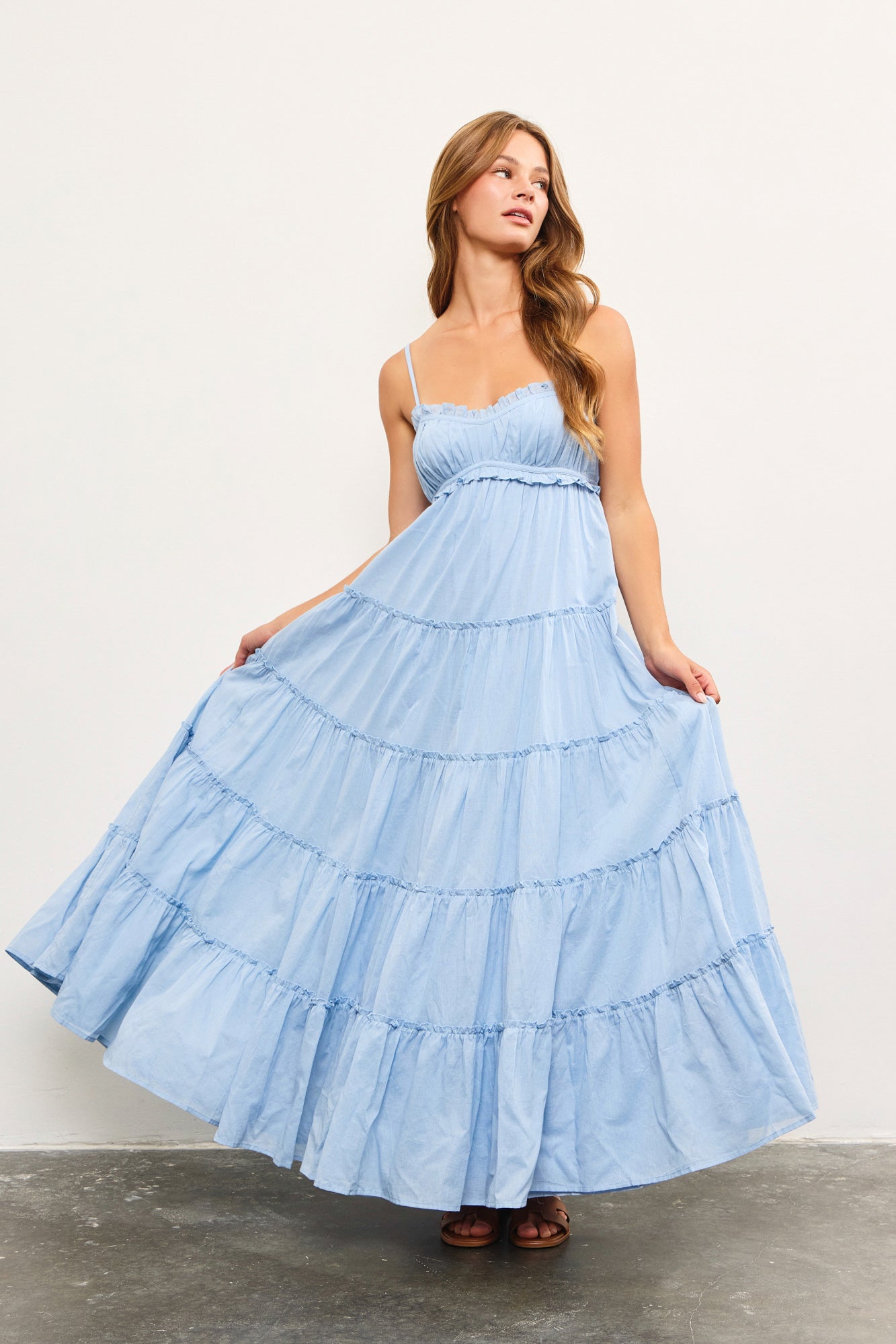 Woman wearing light blue tiered cotton maxi dress with ruffle detail