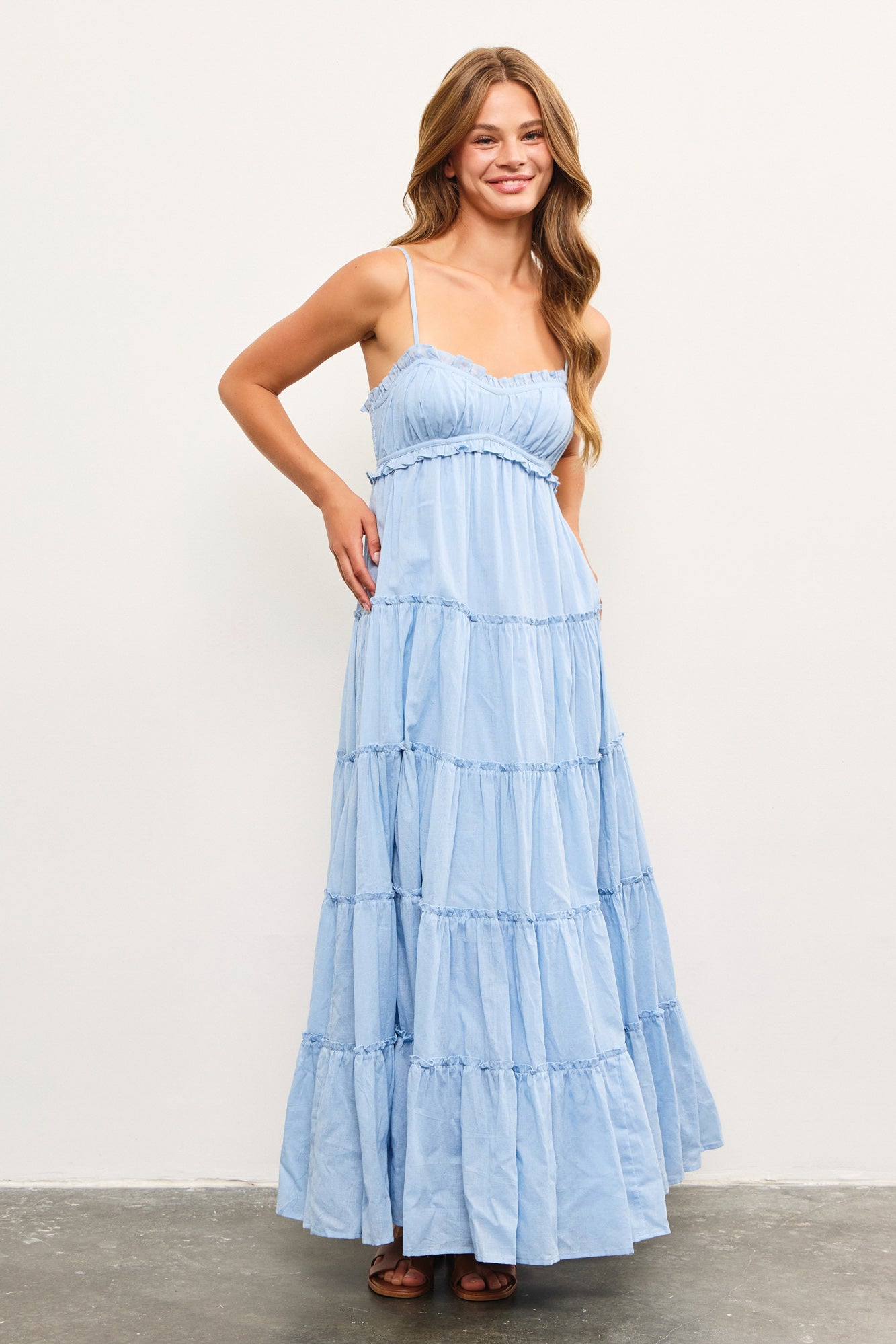 Woman wearing light blue tiered cotton maxi dress with ruffle detail