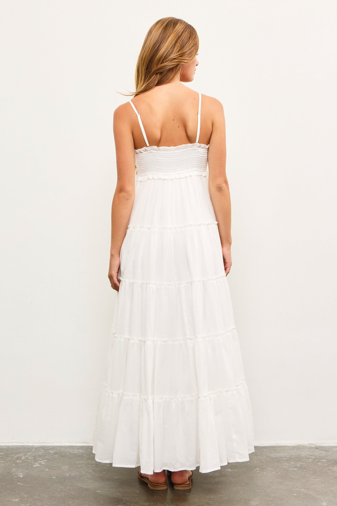 Back view of adjustable strap shirred sundress in white