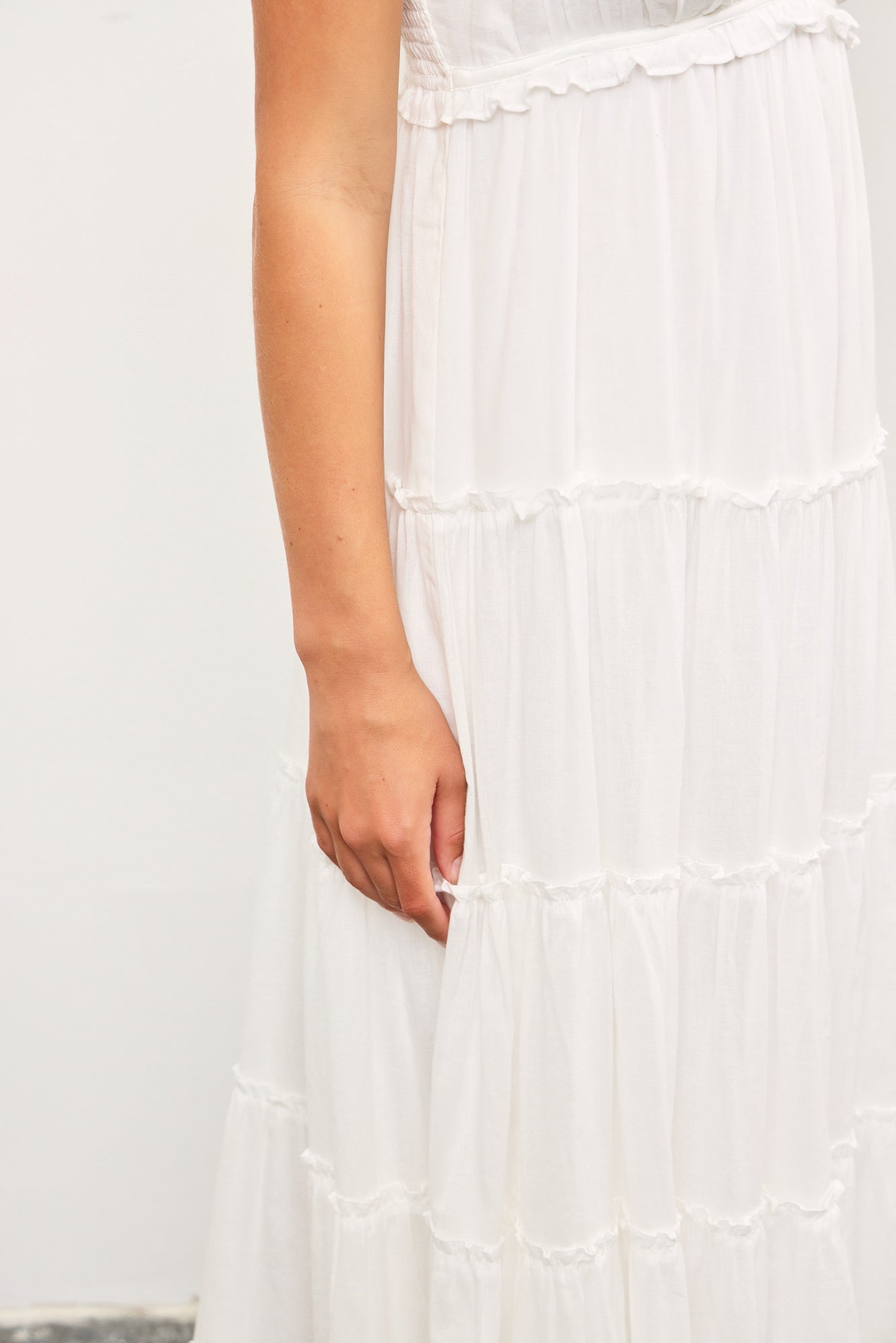 Woman wearing light blue tiered cotton maxi dress with ruffle detail