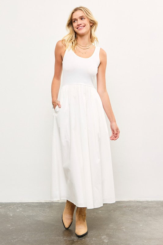 Woman wearing white sleeveless maxi dress with tank top bodice and cotton skirt.