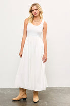 Woman wearing white sleeveless maxi dress with tank top bodice and cotton skirt.