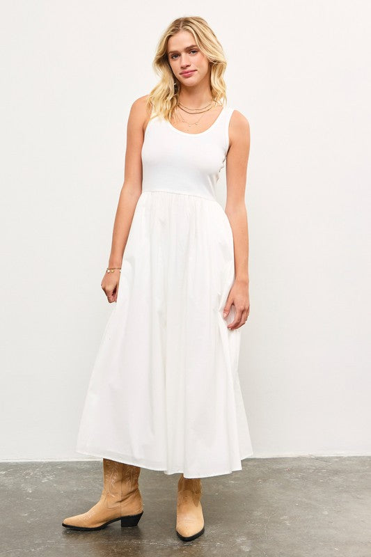 Woman wearing white sleeveless maxi dress with tank top bodice and cotton skirt.