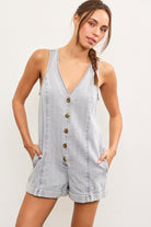 Model wearing sleeveless V-neck light denim romper with button front