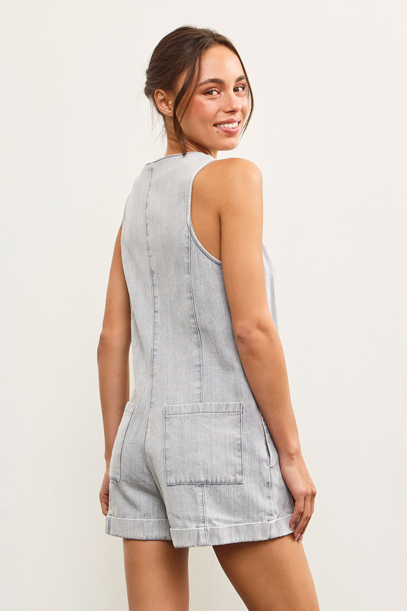 Back view of faded denim playsuit with patch pockets