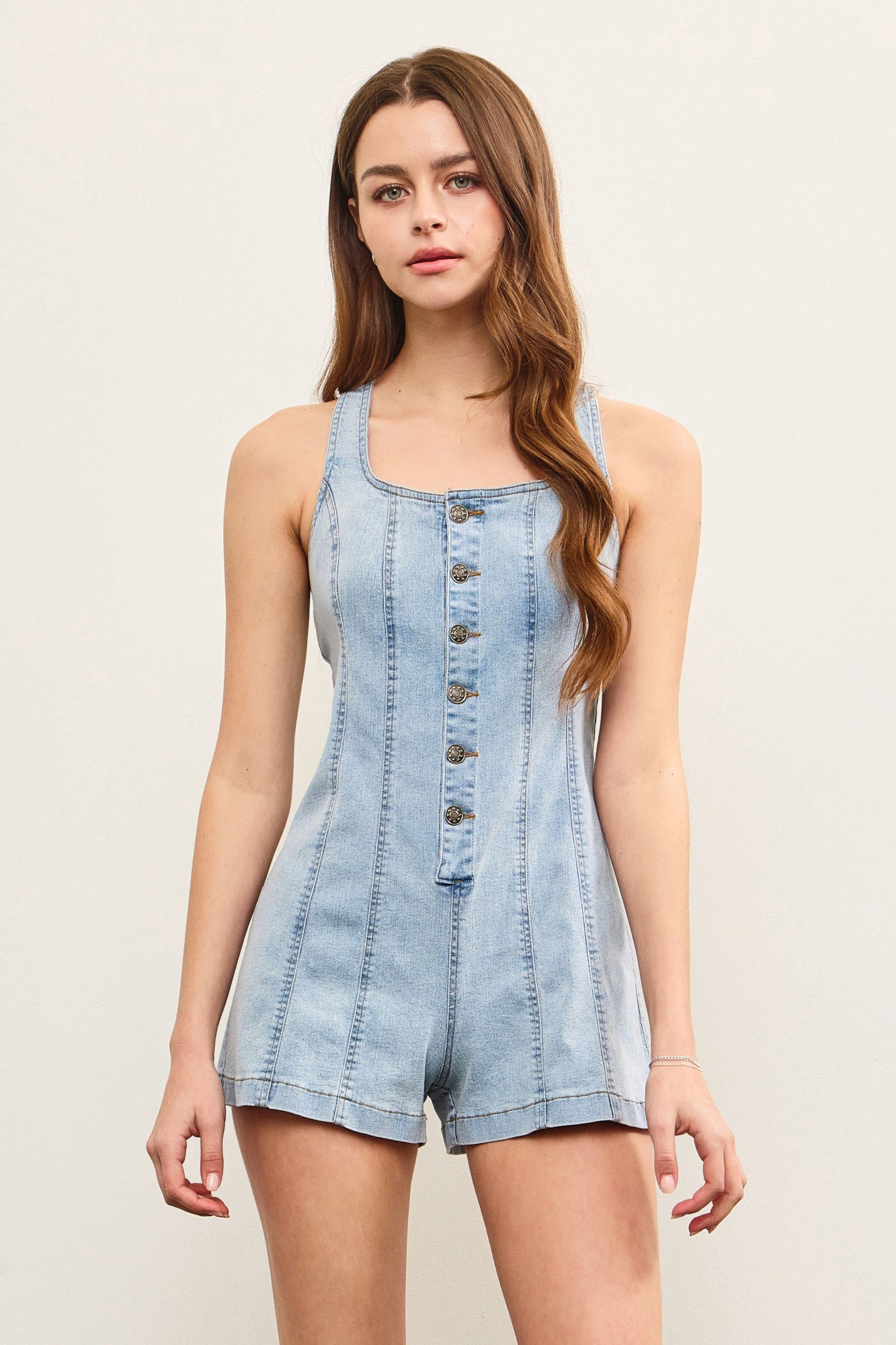 Sleeveless denim jumpsuit with square neckline and vertical seams.