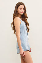 Close-up of light blue denim fabric and button details.